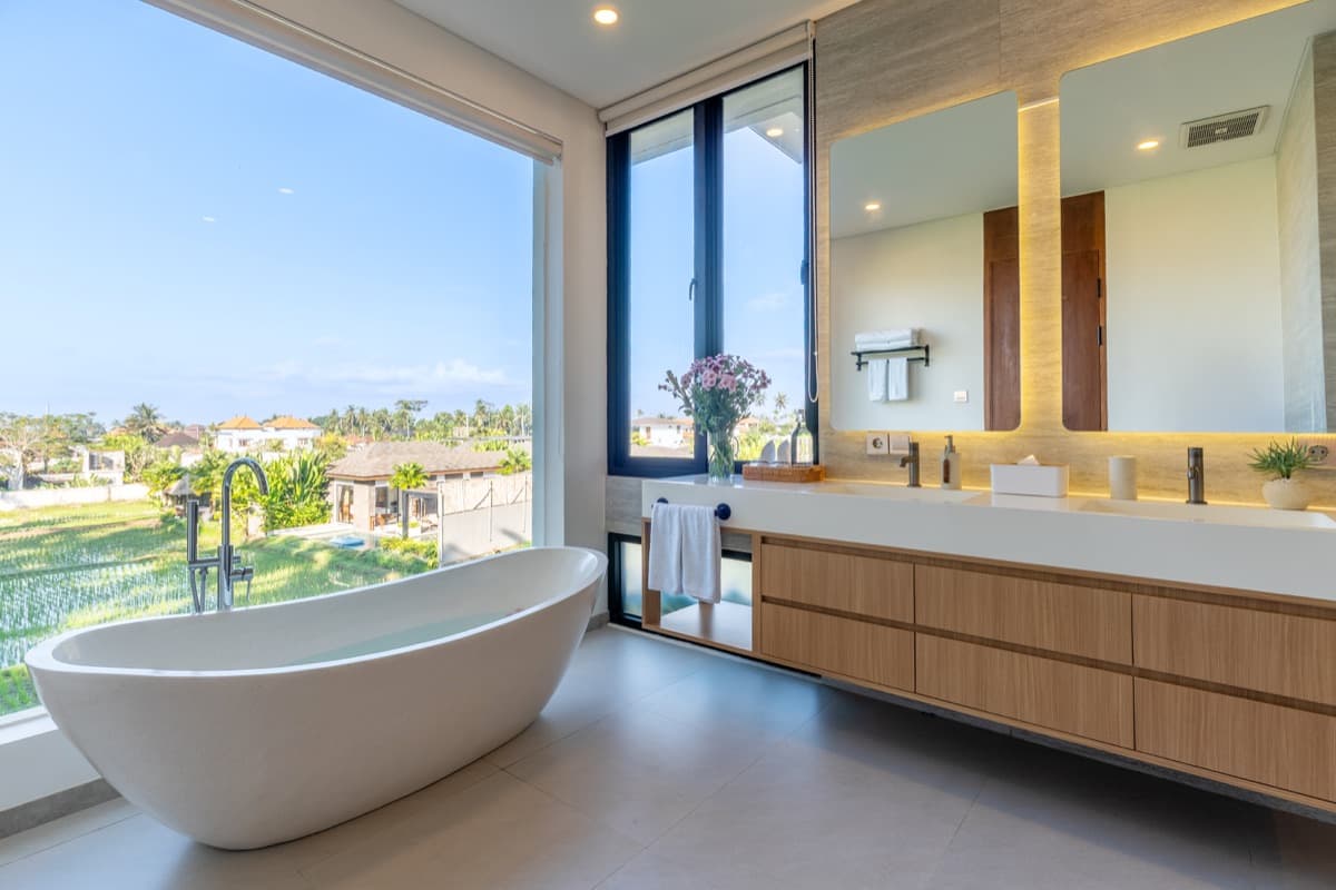 Master bathroom freestanding bathtub with panoramic rice field view at Hubuddha Three Bedroom Villa Ubud Bali