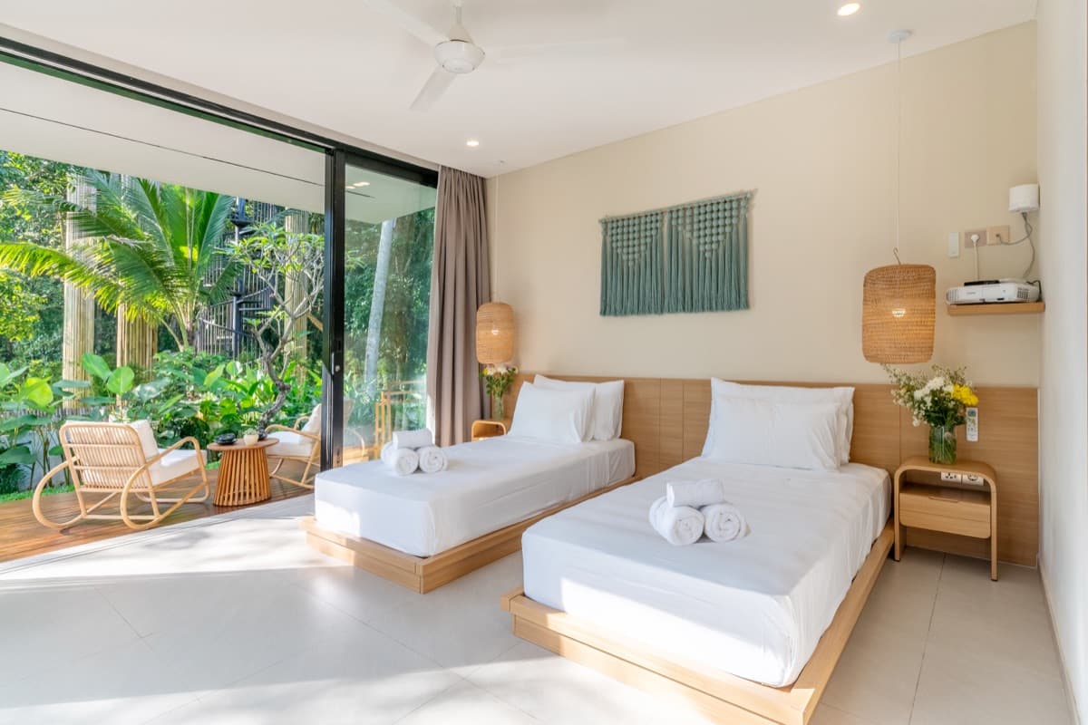Twin bedroom with floor-to-ceiling tropical garden view at Hubuddha Three Bedroom Villa Ubud Bali