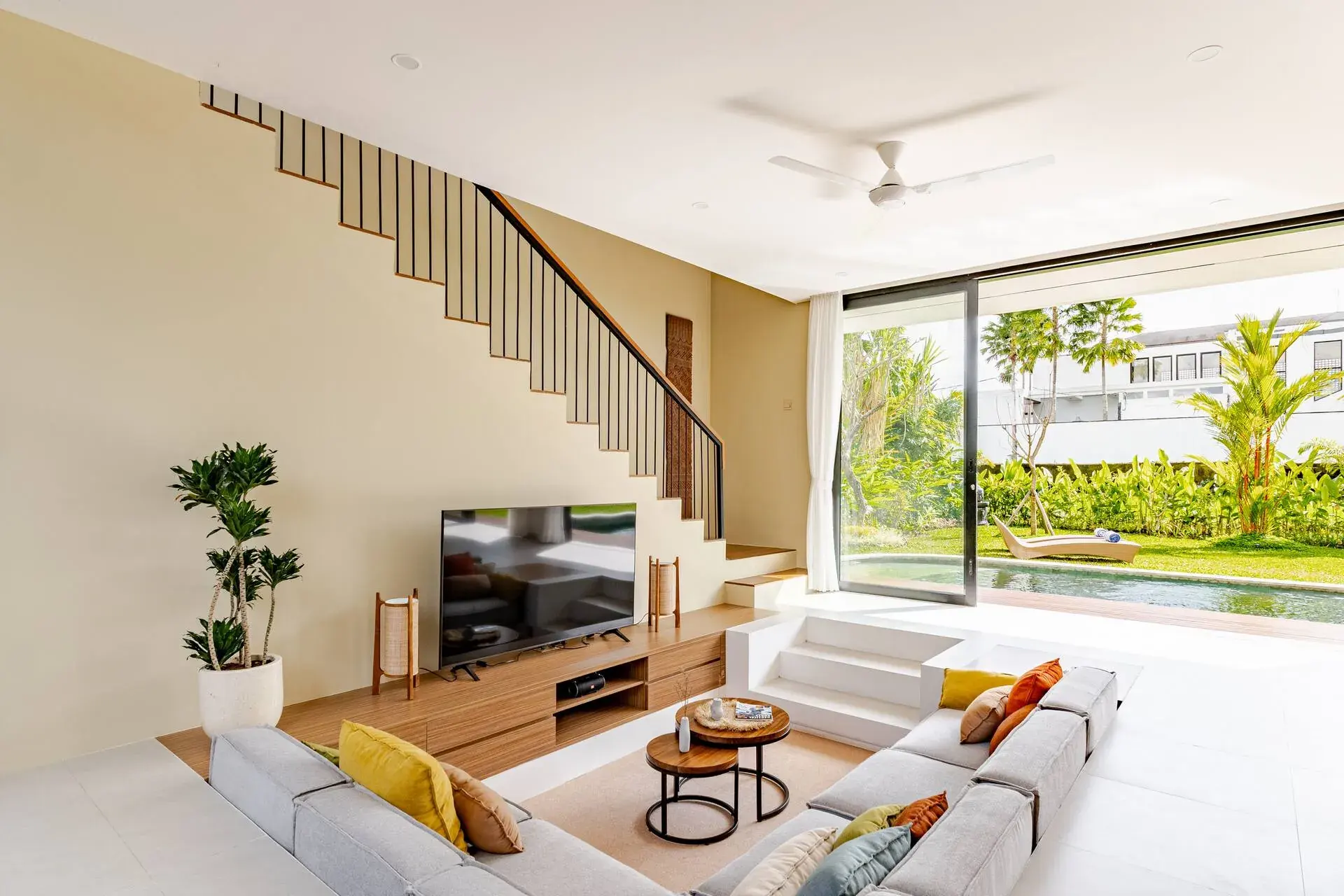 Sala de estar hundida de la Villa 1 con puertas correderas de cristal hacia el jardín