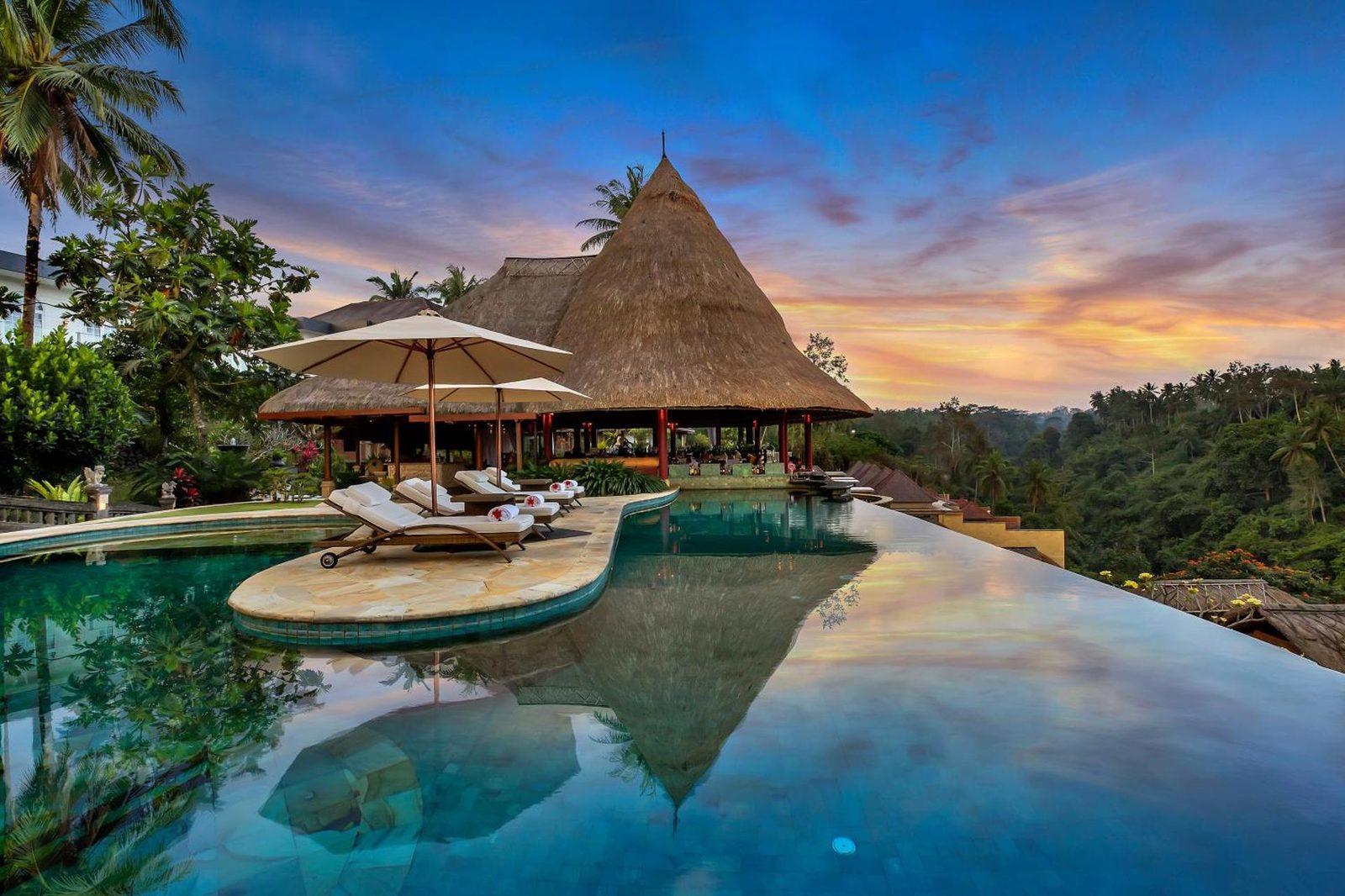 Infinity pool and villa overlooking a green jungle valley at sunset at Viceroy Bali, Ubud