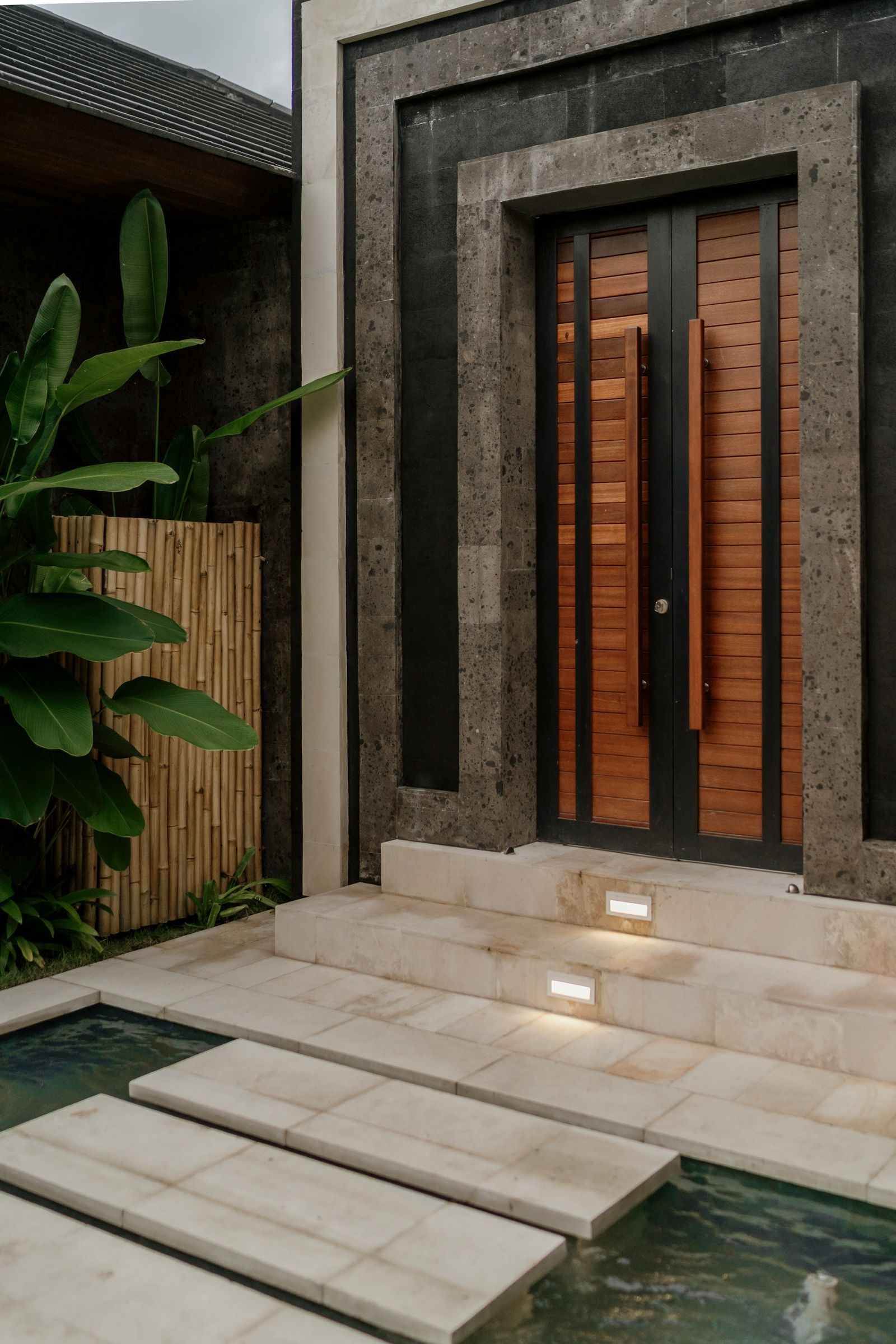 Balinese private villa entrance with a pool and tropical plants