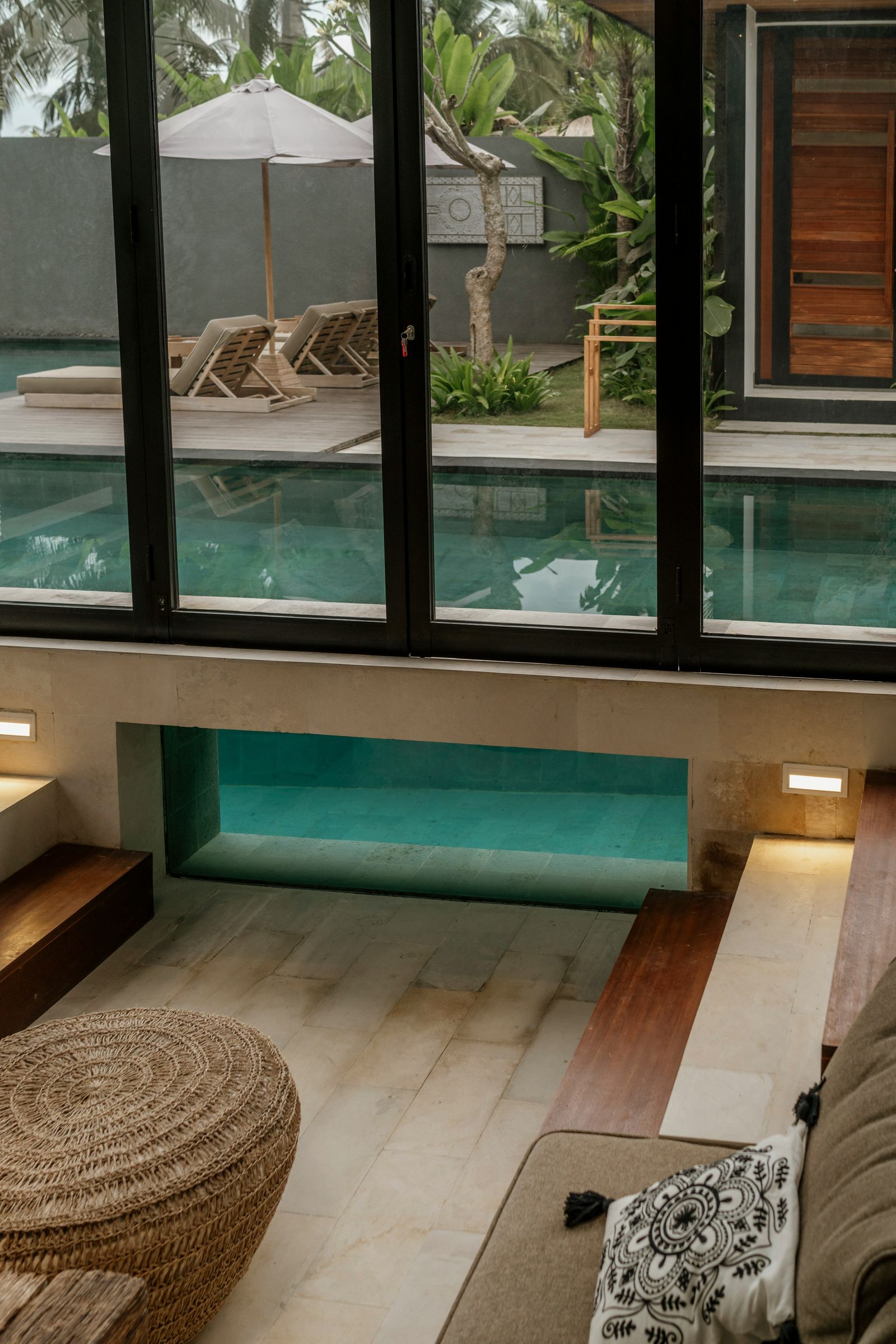 Open Ubud villa living area with a private pool view and tropical greenery