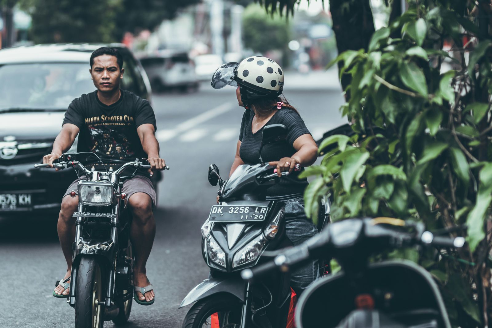 Scooter riders on a road in the Ubud area of Bali