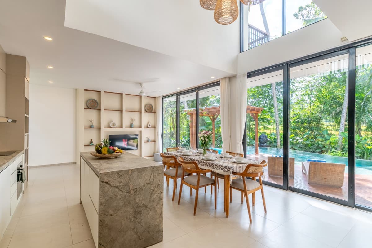 Open-plan kitchen dining and living area with double-height ceilings at Hubuddha Three Bedroom Villa Ubud Bali