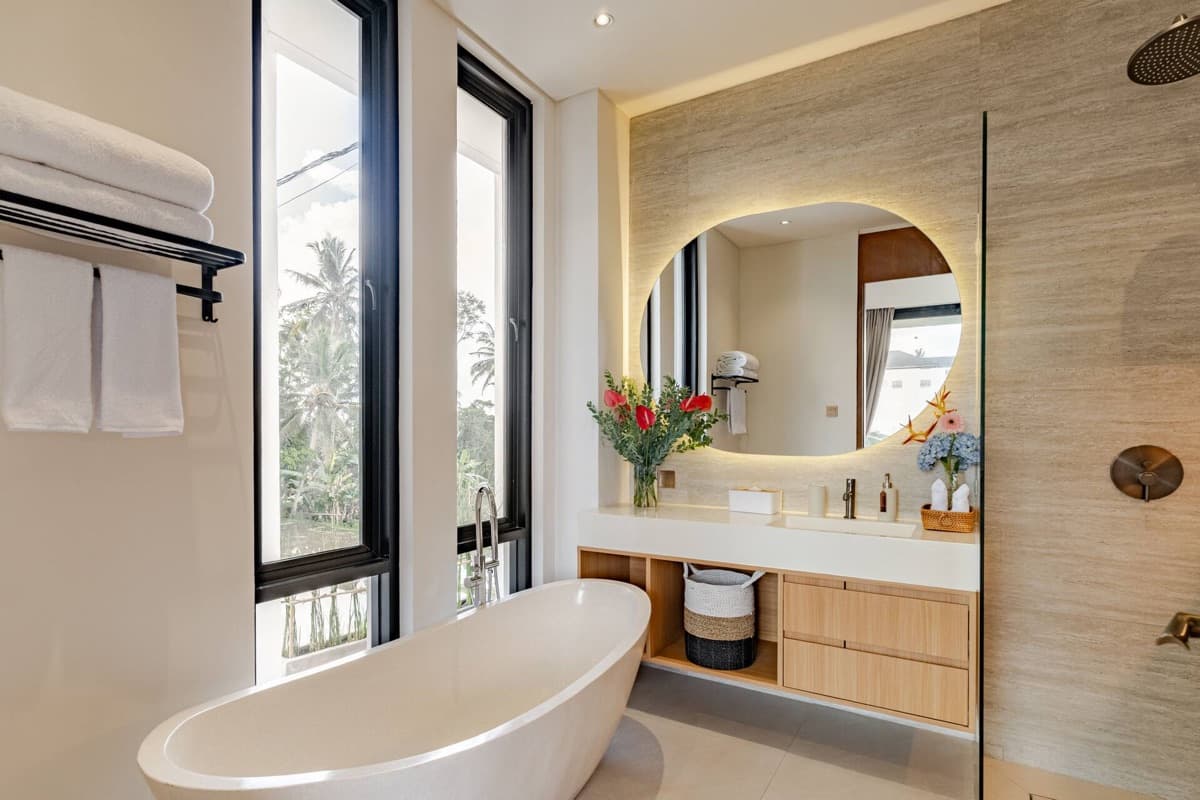 Master bathroom with freestanding bathtub and tropical garden view at Hubuddha Two Bedroom Villa Ubud Bali