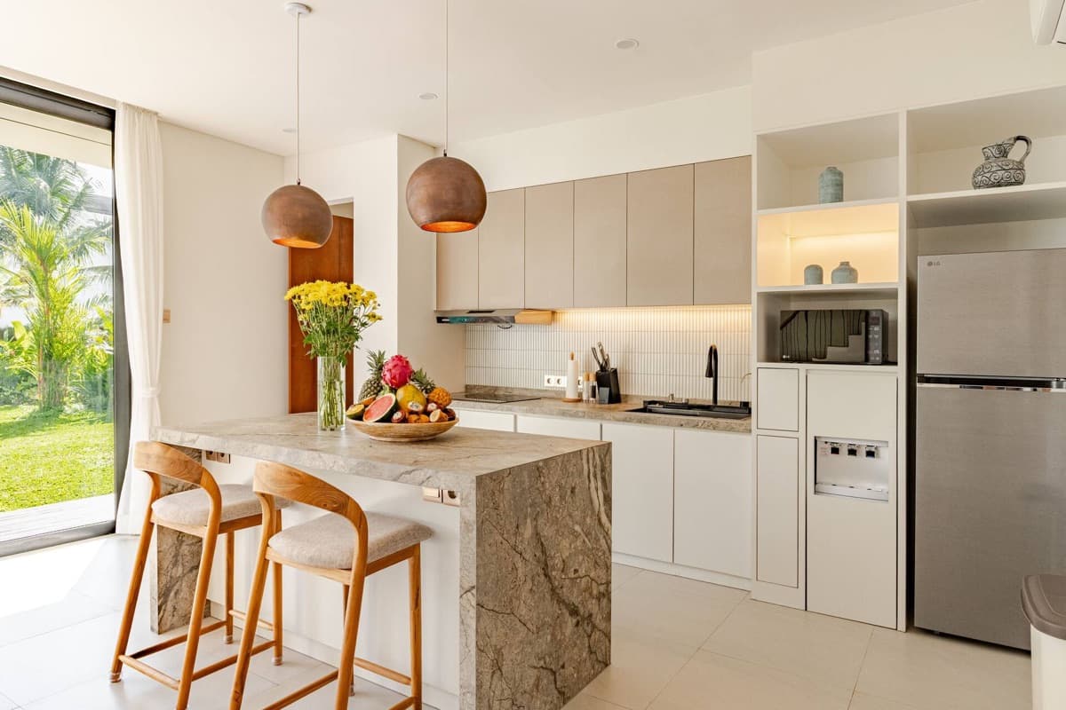 Modern kitchen island with marble top and copper pendant lights at Hubuddha Two Bedroom Villa Ubud Bali